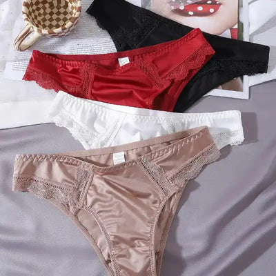 Flat lay of satin bikini panties in black, red, white, and nude with lace trim