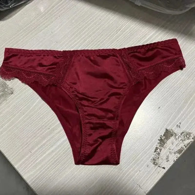 Single burgundy red satin bikini panty with matching lace trim on a white surface