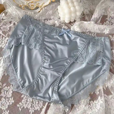 Sky blue satin panties with lace inset panels, scalloped trim, and small bow, lace backdrop