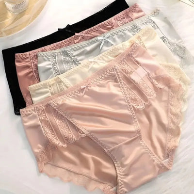 Stack of satin lace panel panties in black, gray, cream, pink, and ivory colors, flat lay