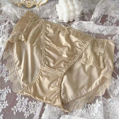 Champagne gold-beige satin panties with lace insets and ruched lace trim, lace backdrop
