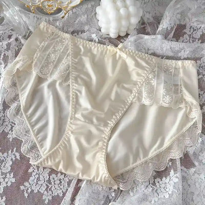 Ivory white satin panties with delicate lace panel inserts and scalloped leg trim, lace backdrop