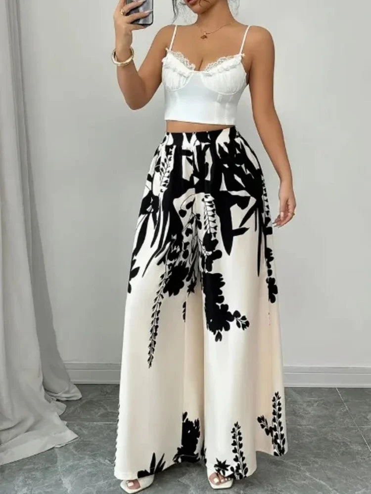 Front close-up of high-waisted ivory wide-leg pants with bold black floral print and black chain bag
