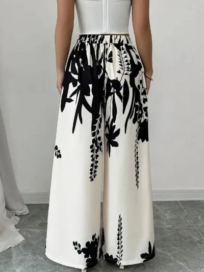 Back view of high-waisted ivory wide-leg pants with black floral and leaf print