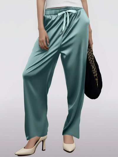 Front view of wide-leg teal satin drawstring pants styled with white heels and black bag