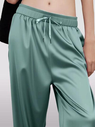 Close-up of teal satin pants elastic waistband with matching satin ribbon drawstring bow