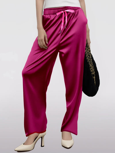Front view of hot pink wide-leg satin drawstring pants with white heels and black bag