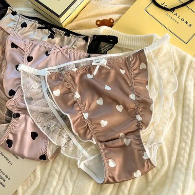 Three pairs of heart print satin panties in pink and brown with lace ruffles