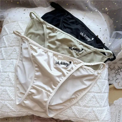 White ivory and black satin bikini briefs with script embroidery flat lay view