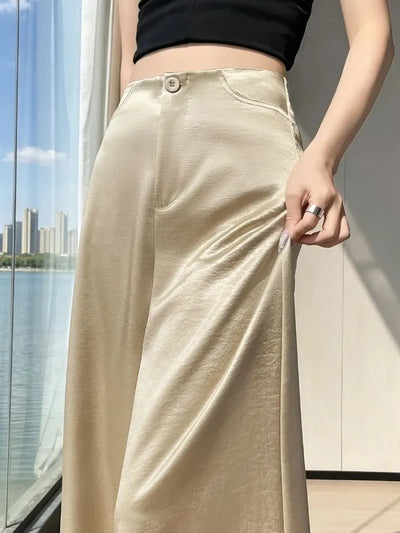 Close-up of champagne wide-leg satin pants waistband with single button and hip pocket detail