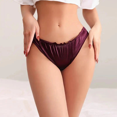 Woman wearing burgundy satin bikini panties with ruffled waistband, front view
