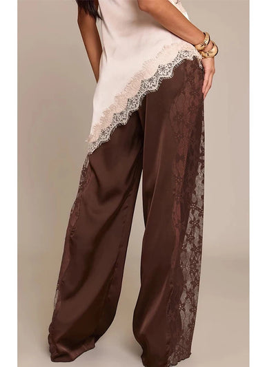 Side view of chocolate wide-leg satin pants showing full-length lace panel detail and floor-grazing hem