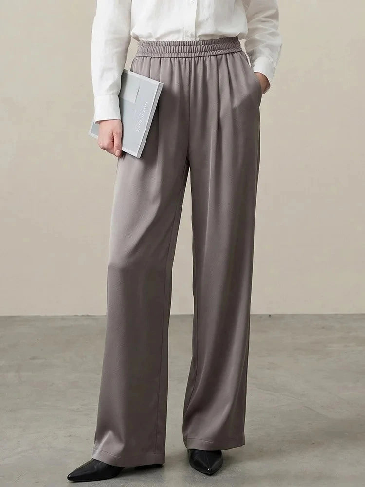 Taupe wide-leg satin pants with elastic waist worn with a white button-down shirt and black flats