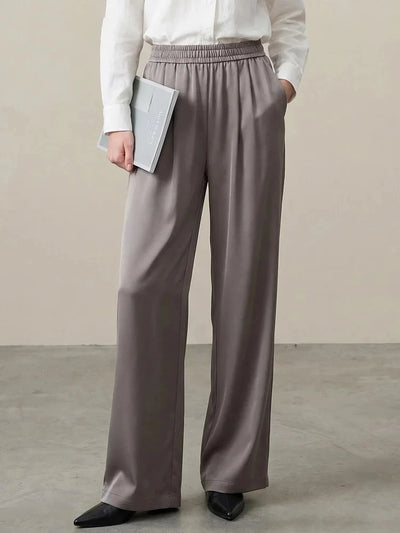 Taupe wide-leg satin pants with elastic waist worn with a white button-down shirt and black flats