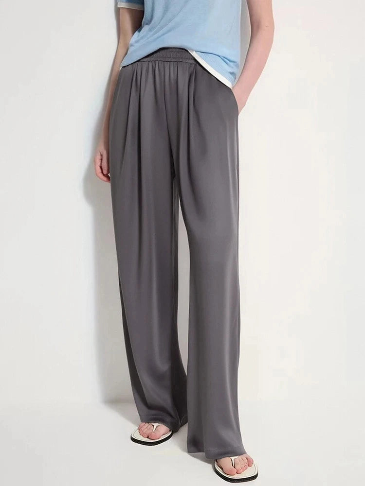 Taupe wide-leg satin pants with elastic waist worn with a white button-down shirt and black flats