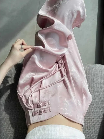 Close-up of pink jacquard frog-button waist detail with self-fabric ties and bamboo motif
