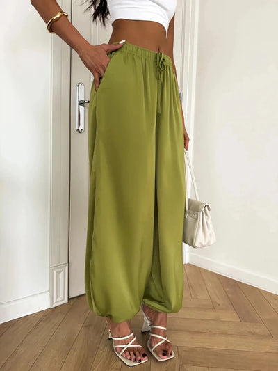 Side view of olive green drawstring balloon pants showing gathered ankle cuffs and fluid drape