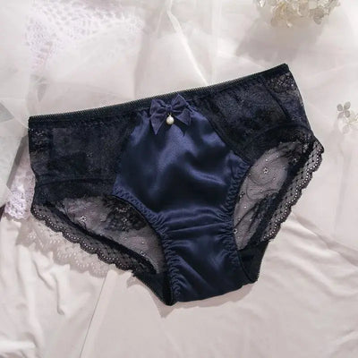 Navy satin panties with floral lace sides, bow, and pearl drop, flat lay