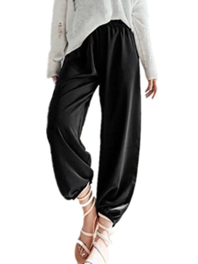 Front view of black fluid tapered pants with elasticized ankle cuffs and elastic waistband on model