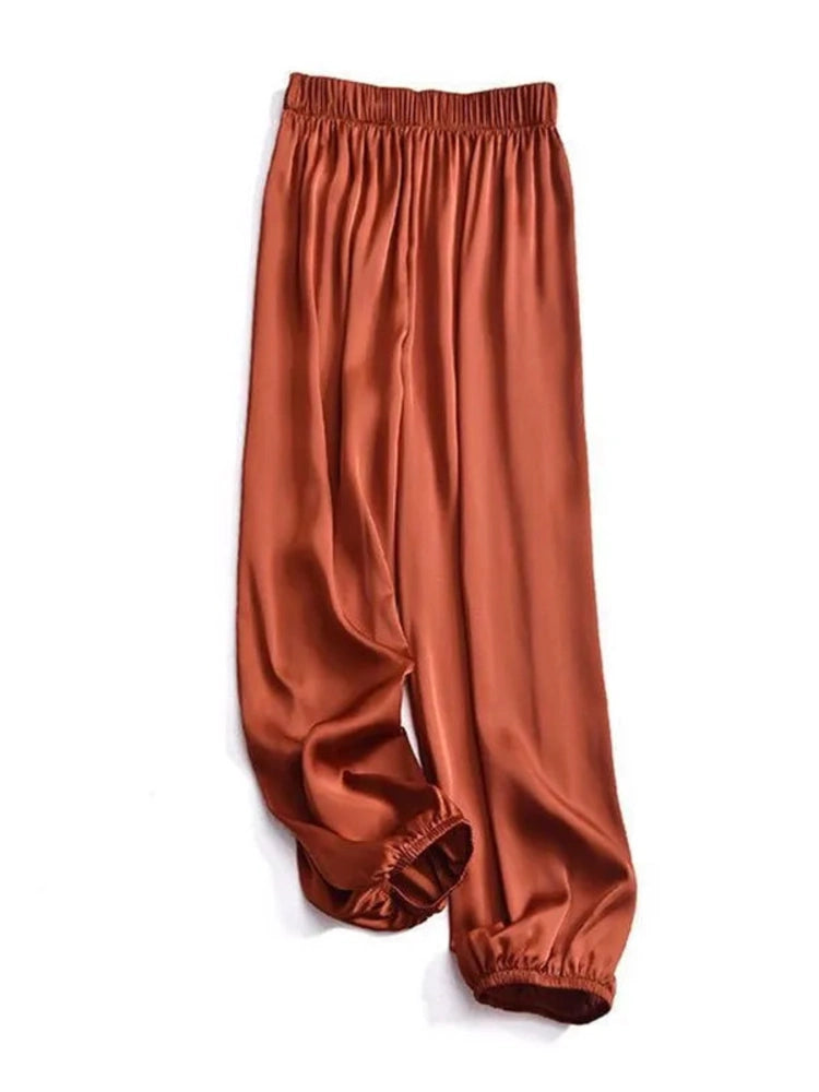 Rust satin balloon-leg pants with elastic waist and gathered ankle cuffs, flat lay