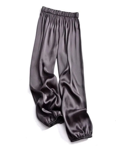 Gray relaxed wide-leg satin pants with elastic waistband and cuffed ankles flat lay