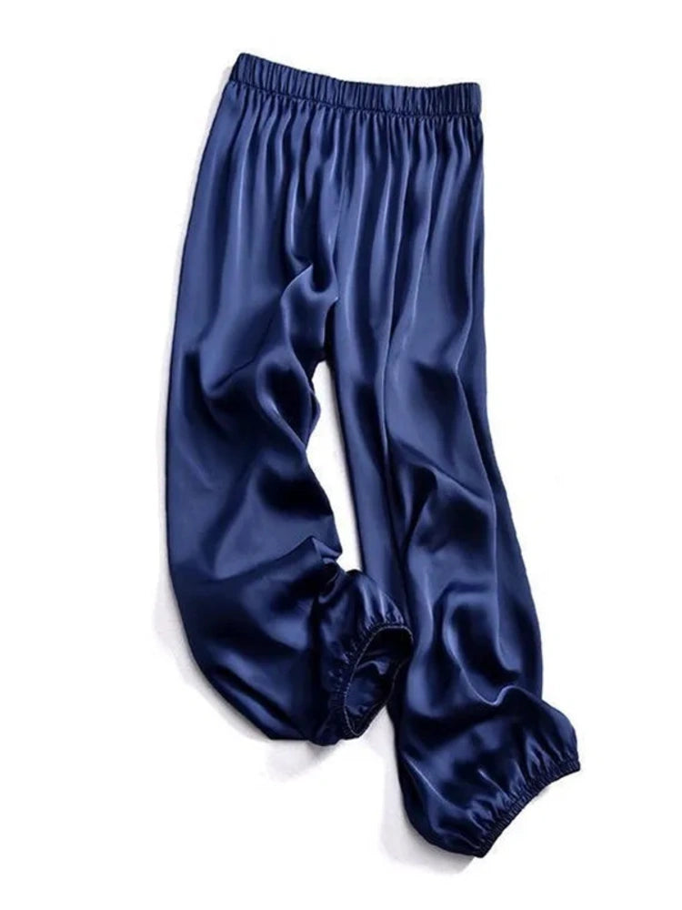 Navy satin wide-leg pants with elastic waistband and cuffed elasticated ankles, flat lay on white background