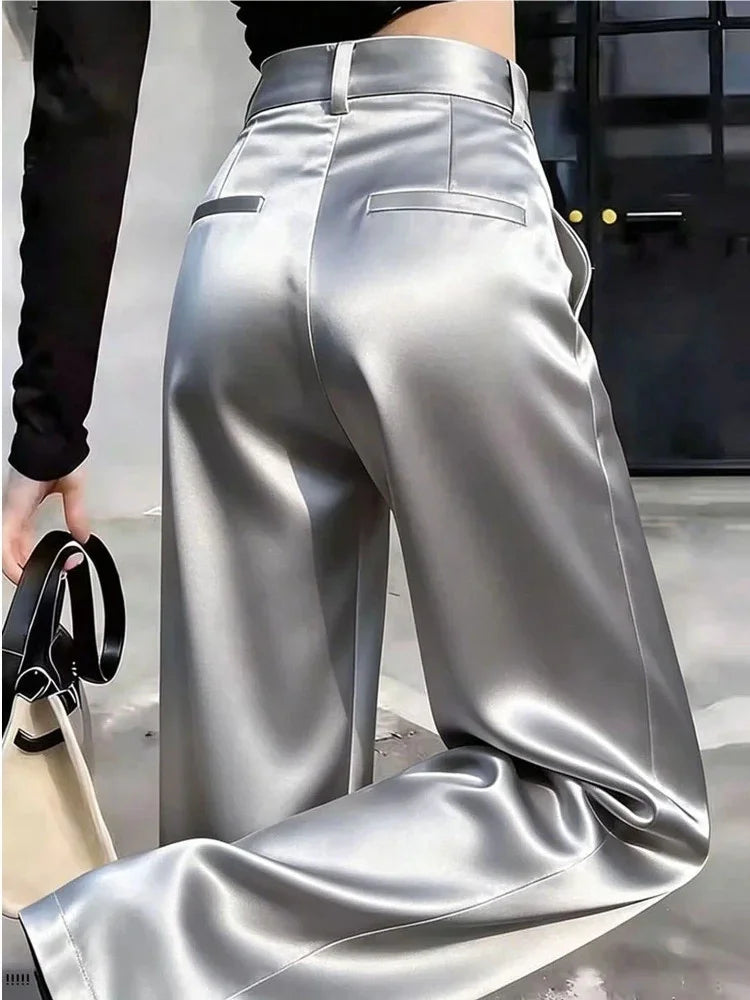 Back view of silver high-rise wide-leg satin pants with suit-style welt pockets and belt loops