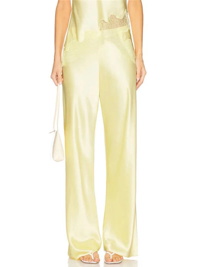 Front view of pale yellow satin wide-leg pants with lace waistband detail styled as a coordinated set