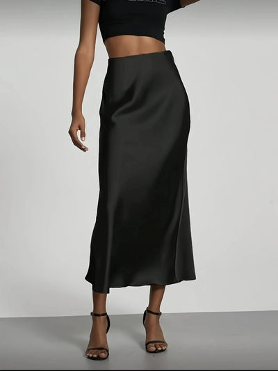 Black high-waist satin midi skirt with A-line flare, styled with black crop top and strappy heels