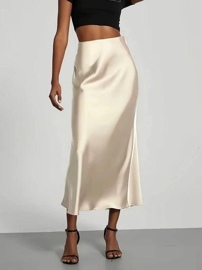 Champagne high-waist satin midi skirt with fluid drape, paired with black crop top and dark heels