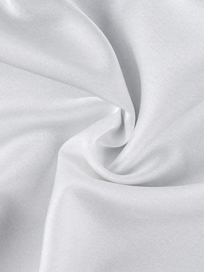 Close-up of smooth white satin fabric showing fluid drape and subtle sheen