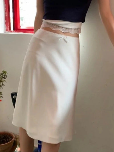 White midi satin skirt with lace waistband and bow, side view close-up on waist detail
