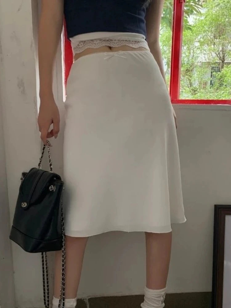 White midi satin skirt with lace waistband and bow, side view close-up on waist detail