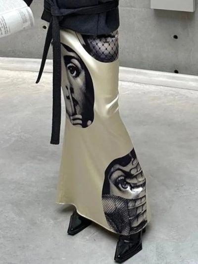 Ivory mermaid satin skirt with Fornasetti face print styled with a belted gray coat and black heels, side view