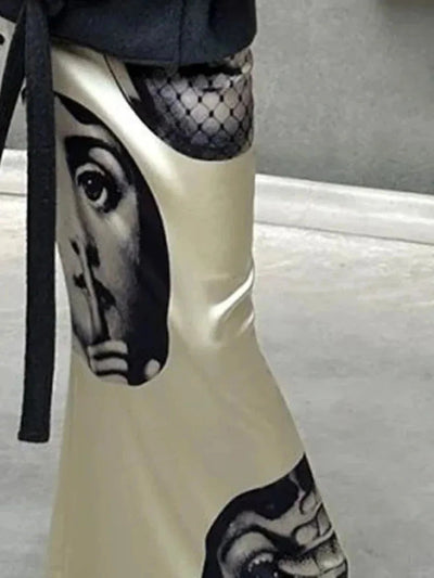 Detail shot of graphic black face print on ivory satin mermaid skirt with gray coat belt