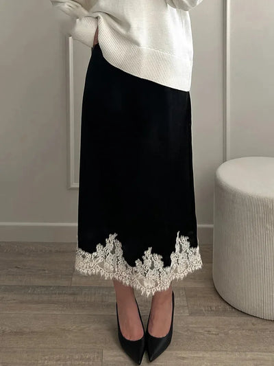 Black velvet midi skirt with ivory floral lace hem worn with white knit sweater and black heels