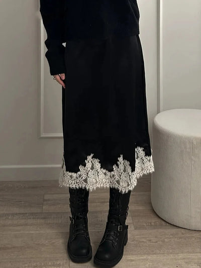 Black velvet midi skirt with ivory lace trim hem styled with black sweater and lace-up combat boots