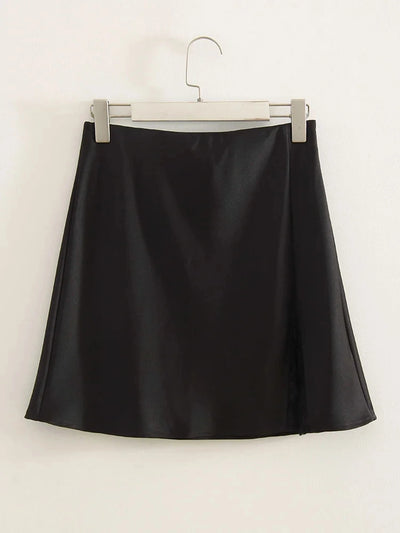Black satin mini skirt with front split hanging on silver clip hanger against white background, back view