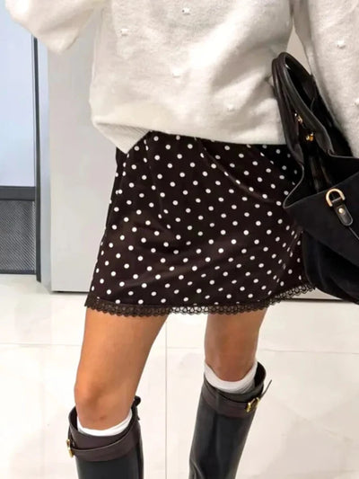 Brown polka dot mini skirt with lace hem displayed on silver mannequin, elastic waistband visible