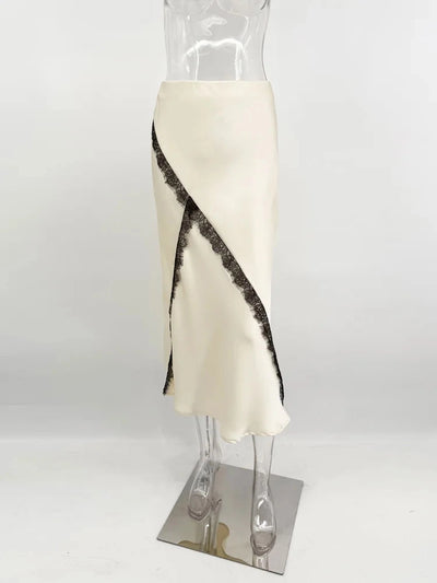 Mannequin displaying ivory satin midi skirt with diagonal black lace trim on white studio background