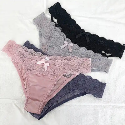 Flat lay of four lace bikini panties in pink, gray, navy and black on white surface