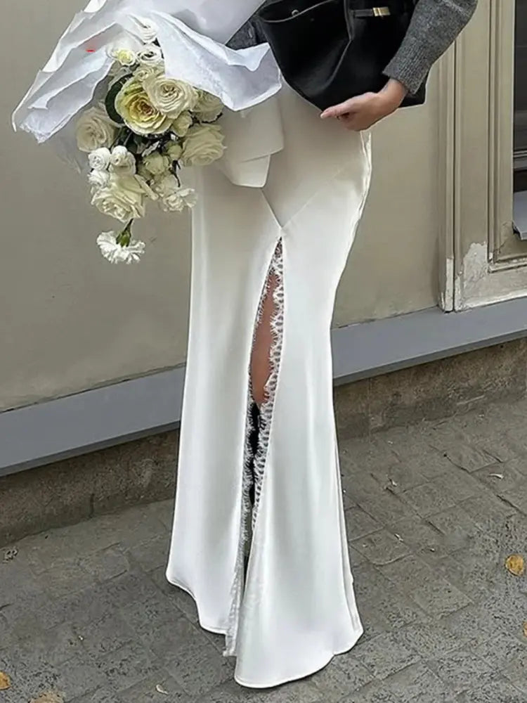 Close-up of white satin mermaid skirt with lace-trimmed front slit at floor length