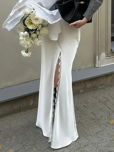 Close-up of white satin mermaid skirt with lace-trimmed front slit at floor length