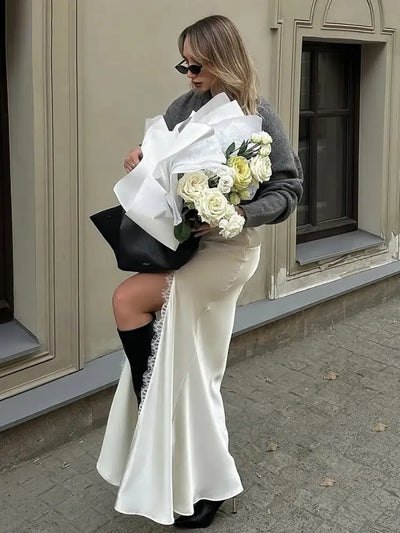 Side view of white mermaid skirt with lace slit and black knee-high boots