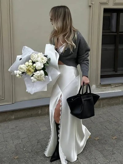 Back view of woman in white satin mermaid skirt with visible lace slit detail