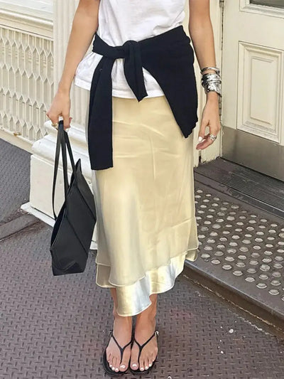 Champagne midi skirt styled with knotted black cardigan, white tee, and black tote bag