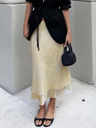 Champagne sheer midi skirt paired with belted black jacket and small black bag, street style