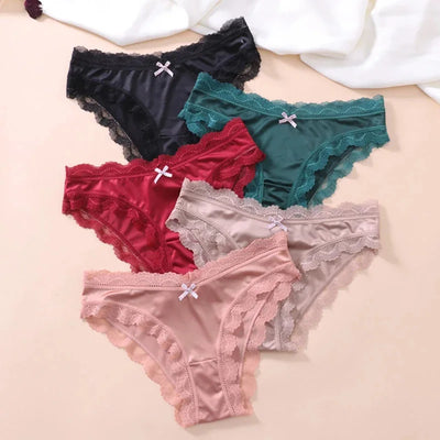 Five pairs of lace-trim satin bikini panties laid flat in black, teal, burgundy, nude, and pink