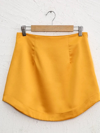 Yellow satin mini skirt on hanger with clean silhouette and high waistband
