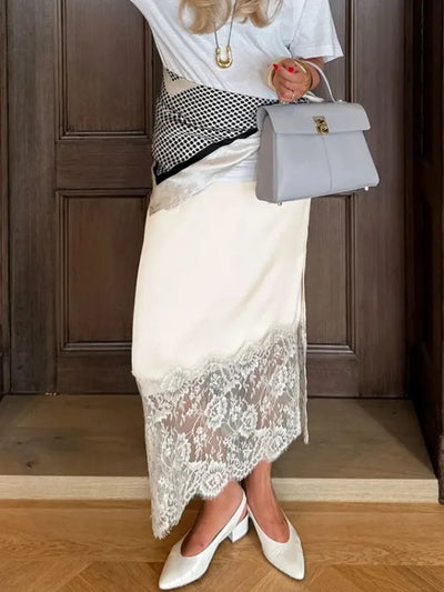 Full-length view of ivory lace-hem midi skirt paired with white slingbacks and structured gray handbag